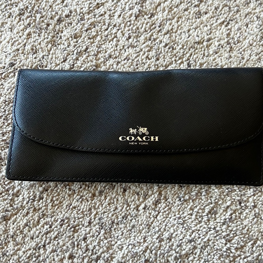 A black leather Coach Wallet. It is larger in size. No rips or tears.